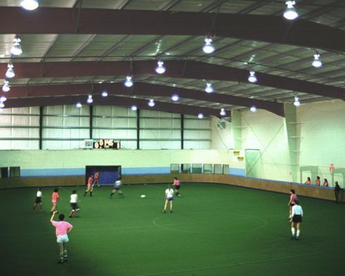 A Group of People Are Playing Indoor Soccer in An Indoor Stadium - Redmond, WA - Commercial Industries
