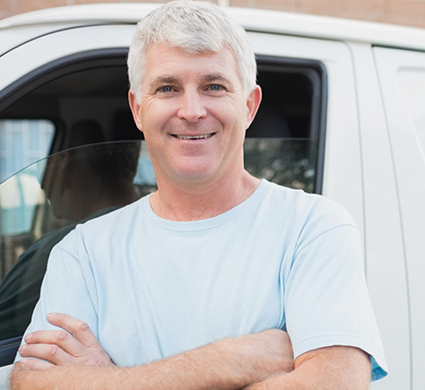 A man standing in front of a white van with his arms crossed