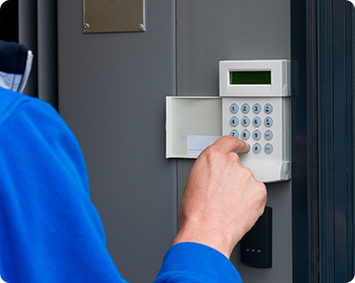A person is pressing a button on a security system.