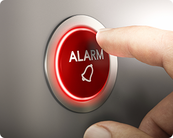A person is pressing an alarm button with their finger