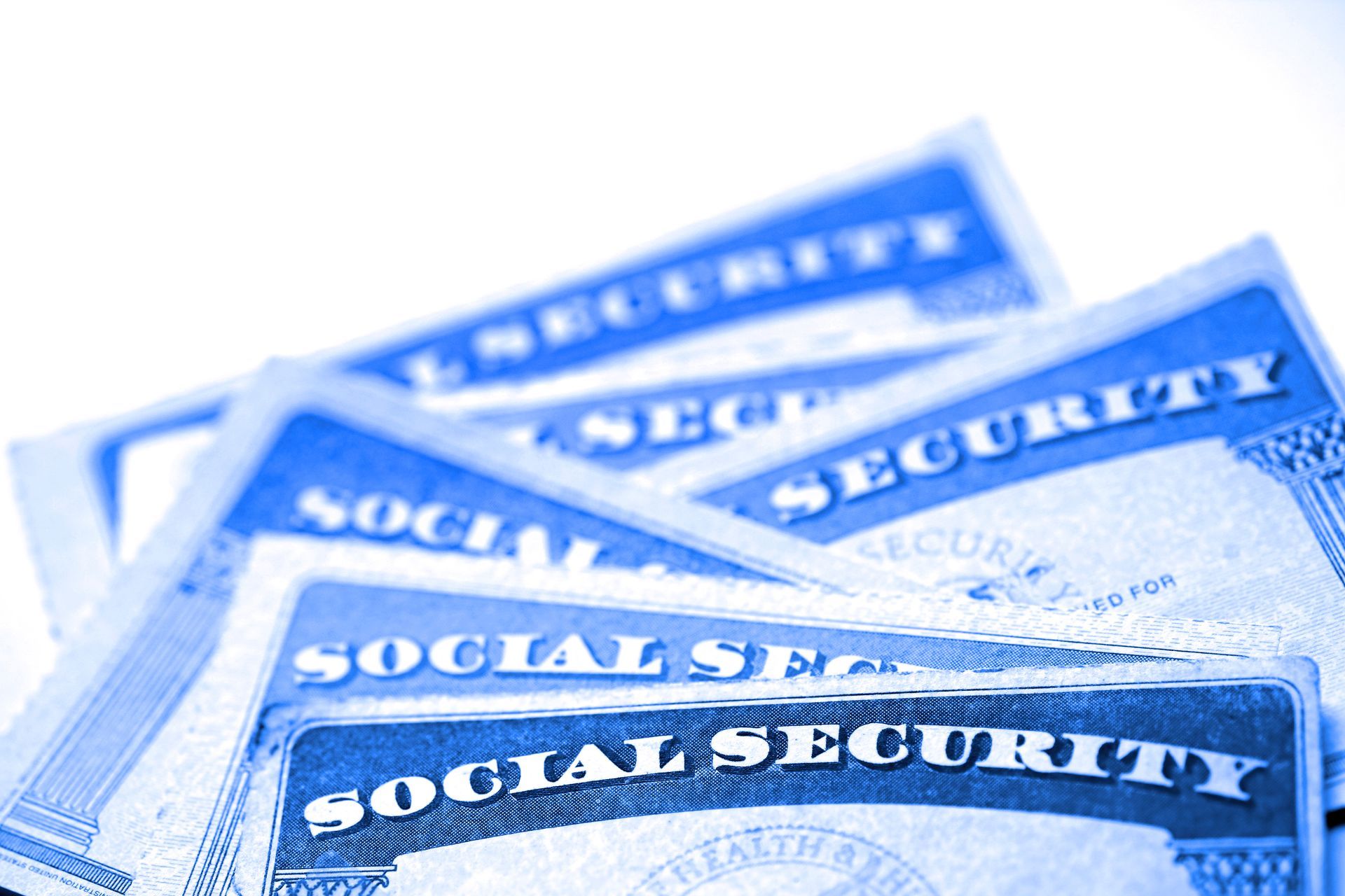 Close-up view of multiple Social Security cards arranged in a layered pattern, representing SS