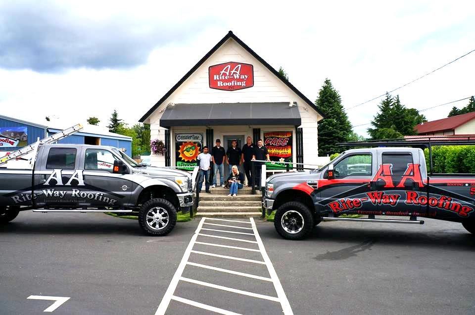 Two trucks flank a building. People stand on steps. 