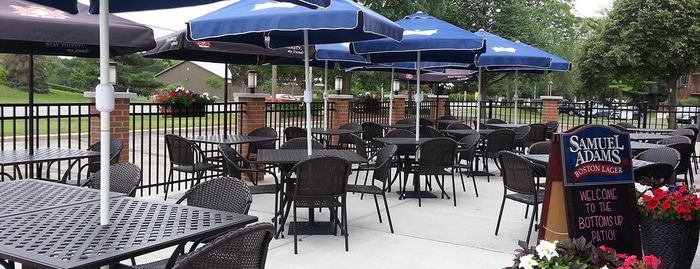 A patio with tables and chairs and blue umbrellas