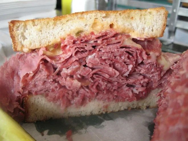 A corned beef sandwich is cut in half on a plate