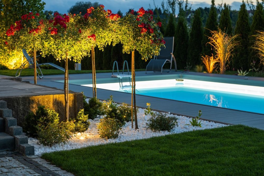 Una piscina è illuminata di notte in un cortile.
