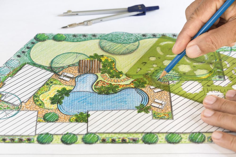 Una persona sta disegnando un giardino con uno stencil e una matita.