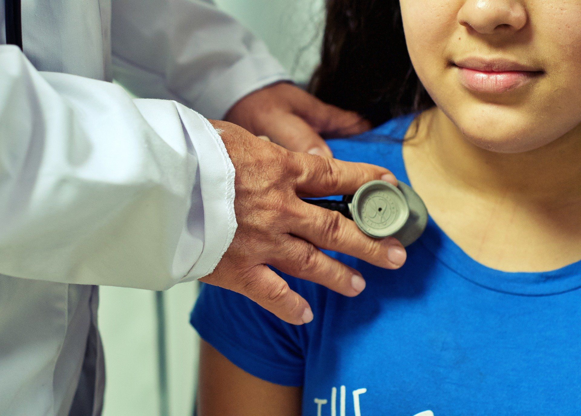 A doctor is listening to a woman's heart using a stethoscope