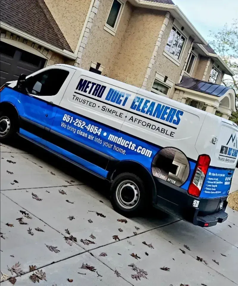 A metro duct cleaners van is parked in front of a house