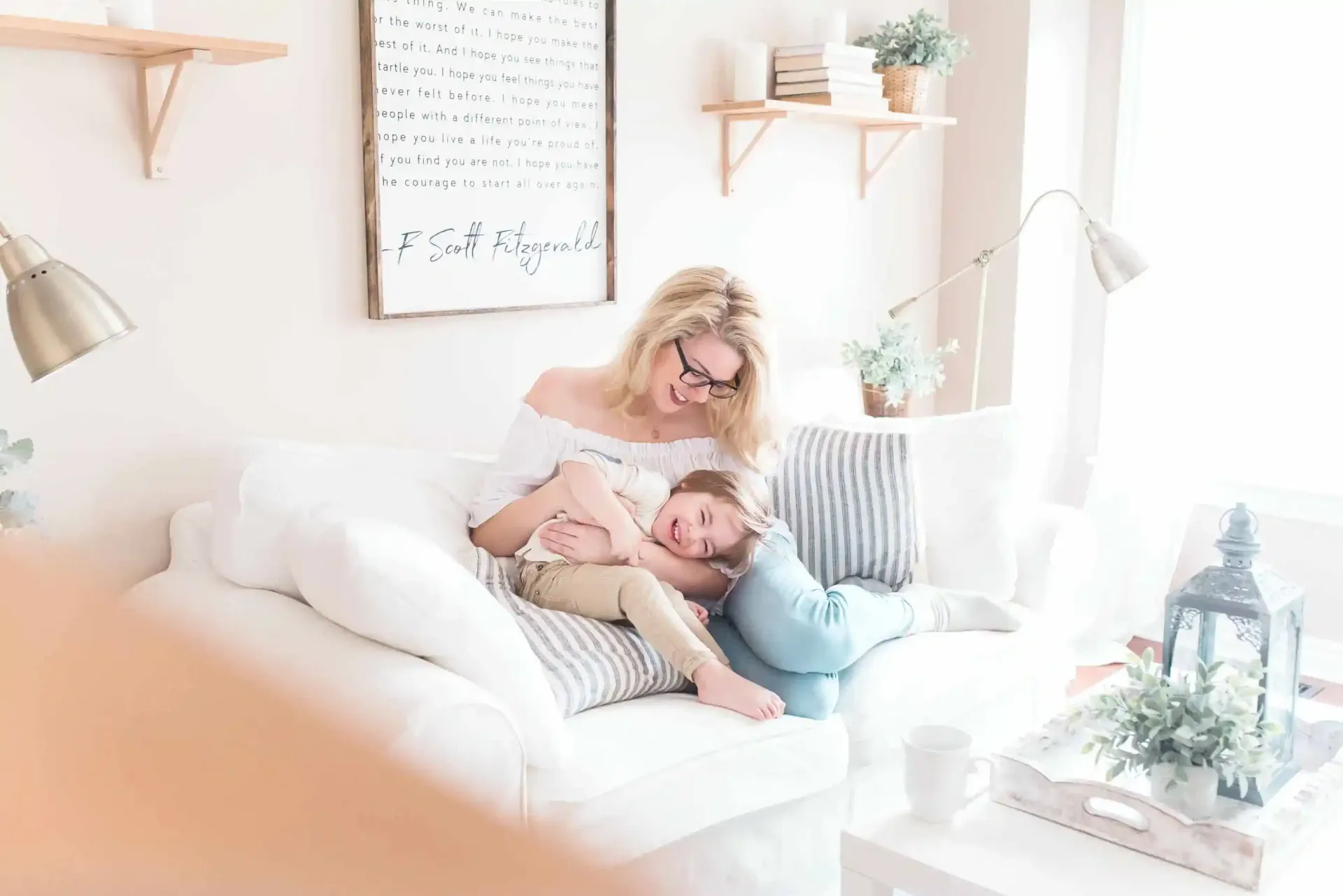 A woman is sitting on a couch holding a child.