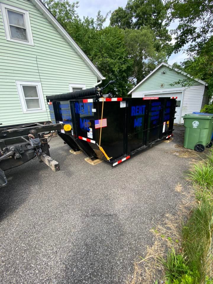 A black dumpster labeled 