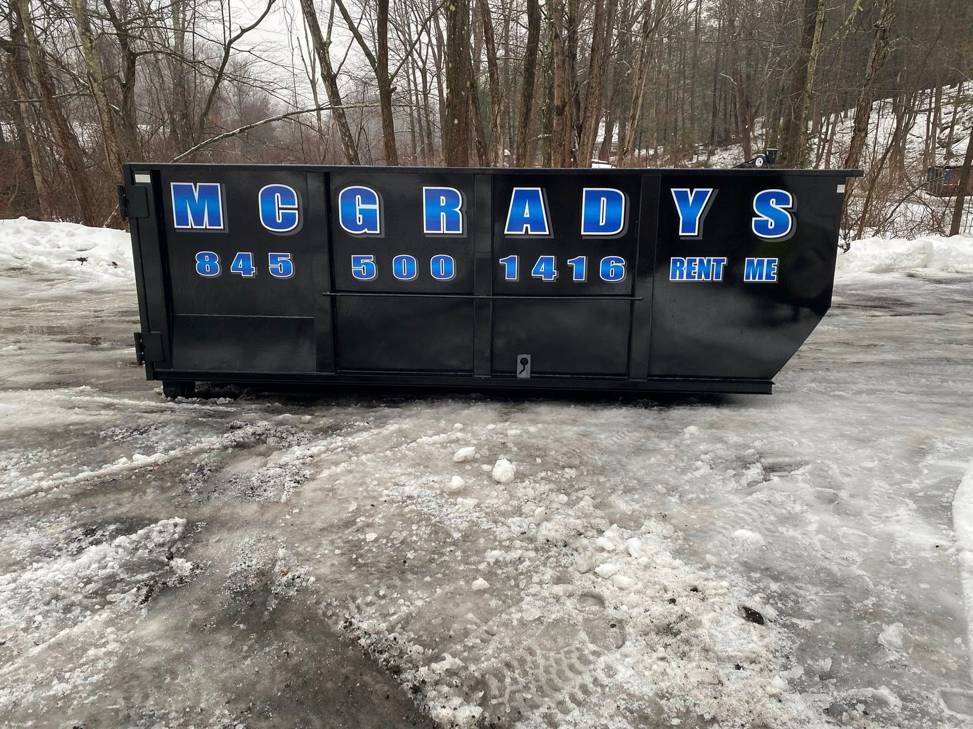 A black industrial dumpster with blue 