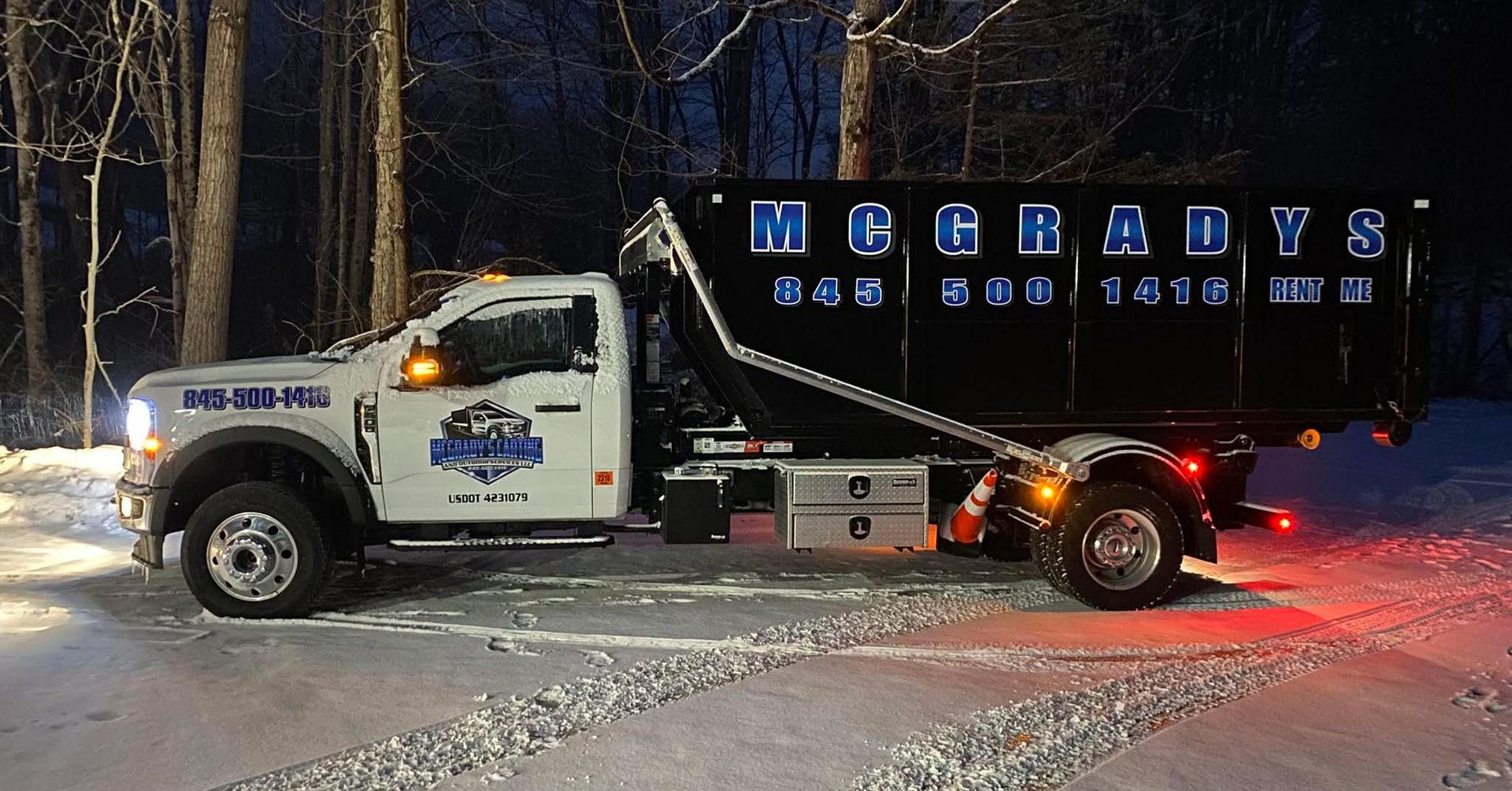 A white dump truck with a black container labeled 