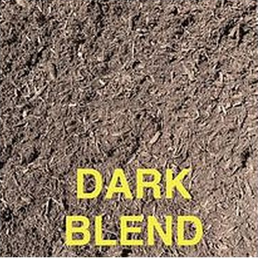 A close-up of dark brown mulch or soil texture with the text 