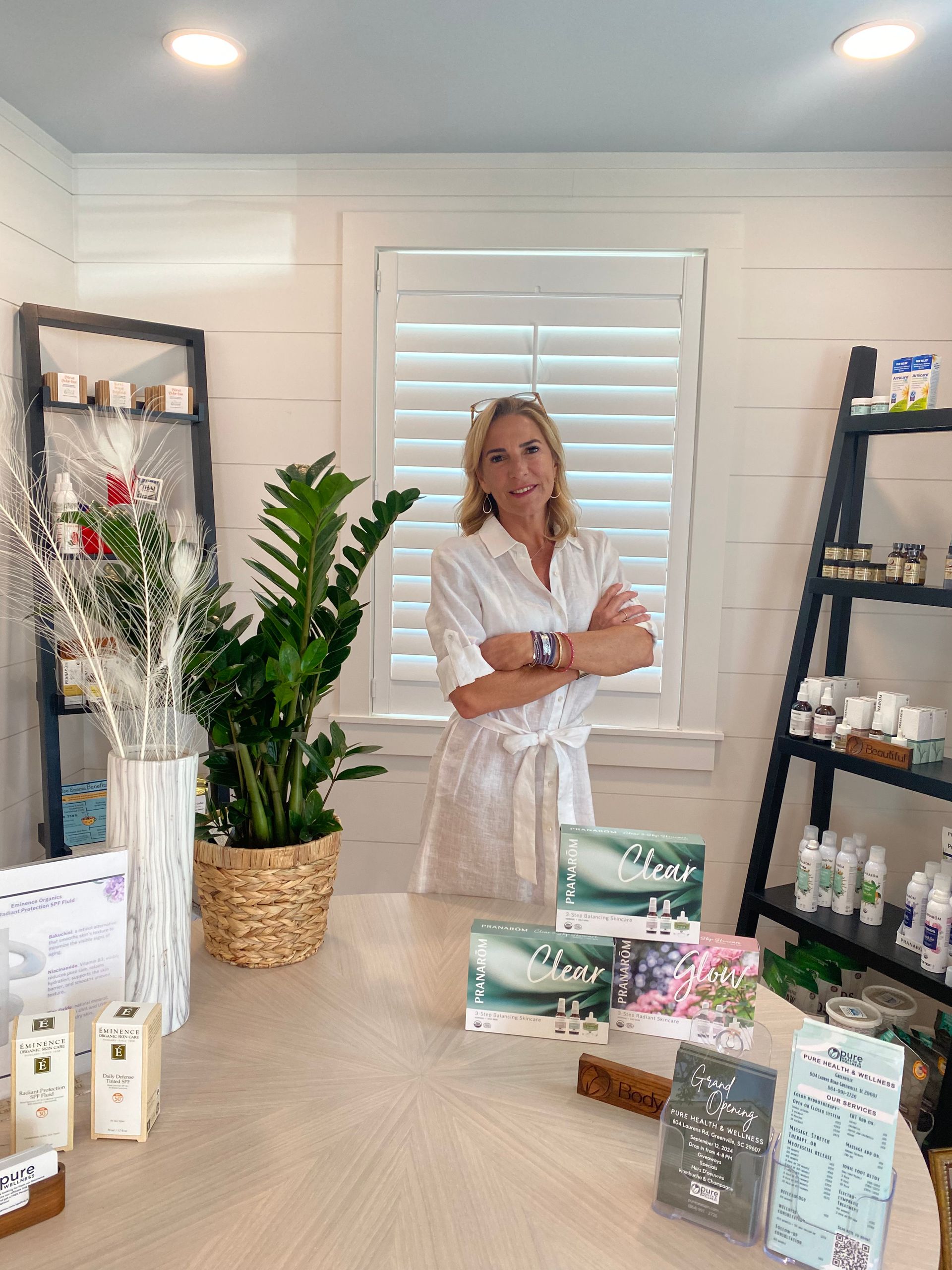 Woman standing in a bright boutique with shelves of candles and packaged goods