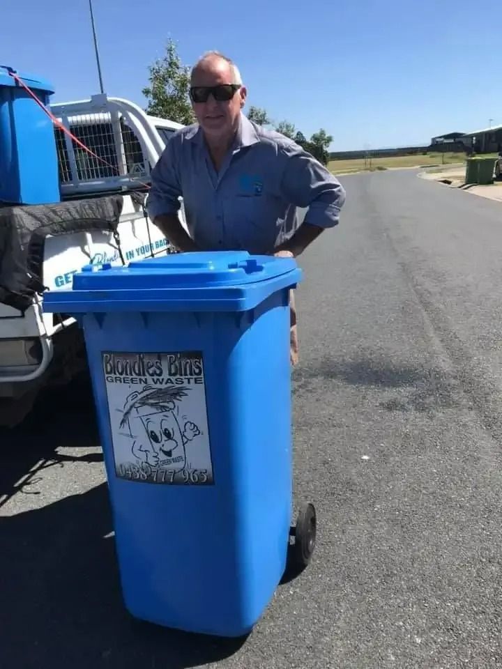 Man Standing Next to Blue Trash Bin Labelled — Blondies Bins in Whitsundays, QLD