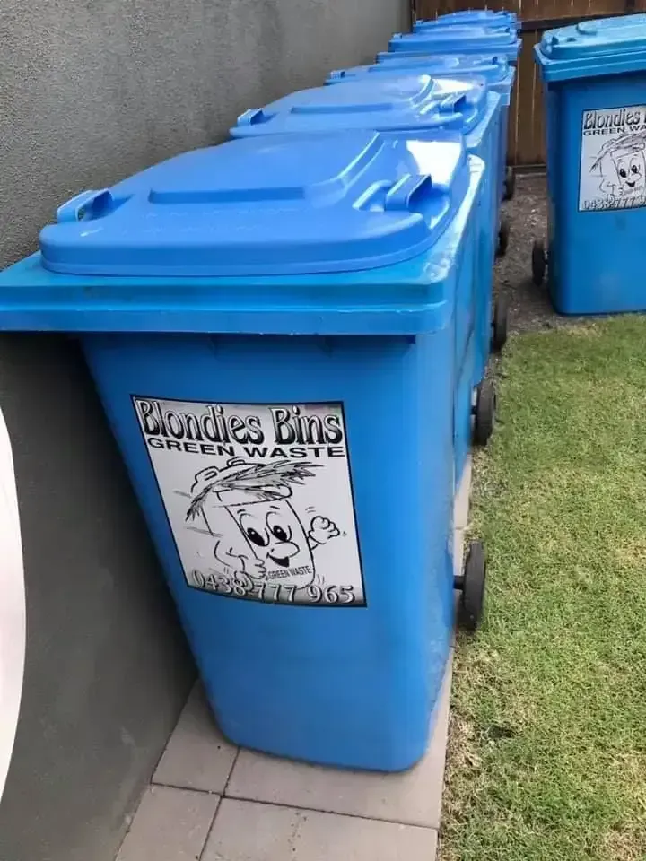 Blue Trash Bins Lined Up Against a Wall — Blondies Bins in Cannonvale, QLD