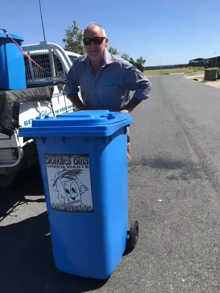 Man Standing Next to a Blue Trash Bin — Blondies Bins in Proserpine, QLD