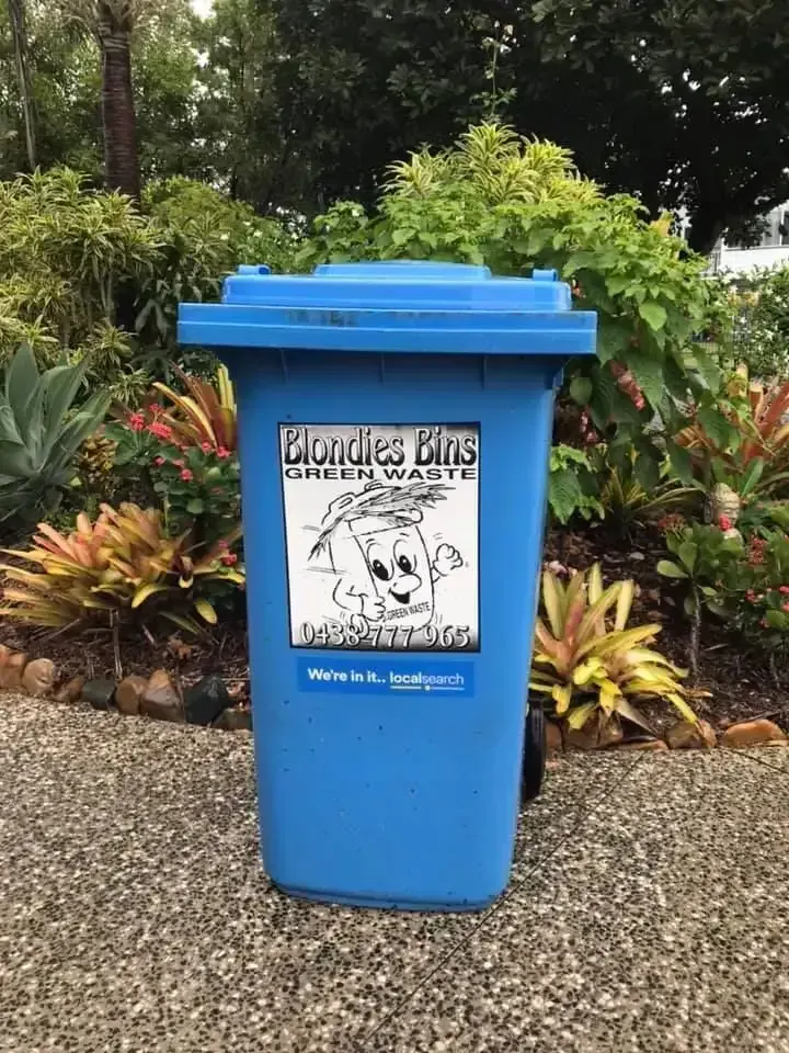 A Blue Trash Can Is Sitting On The Ground Next To A Garden — Blondies Bins in East Mackay, QLD