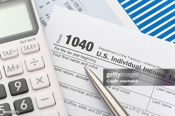 Man and woman at a desk reviewing documents. The man smiles and gestures. Sunlight streams in from a window.