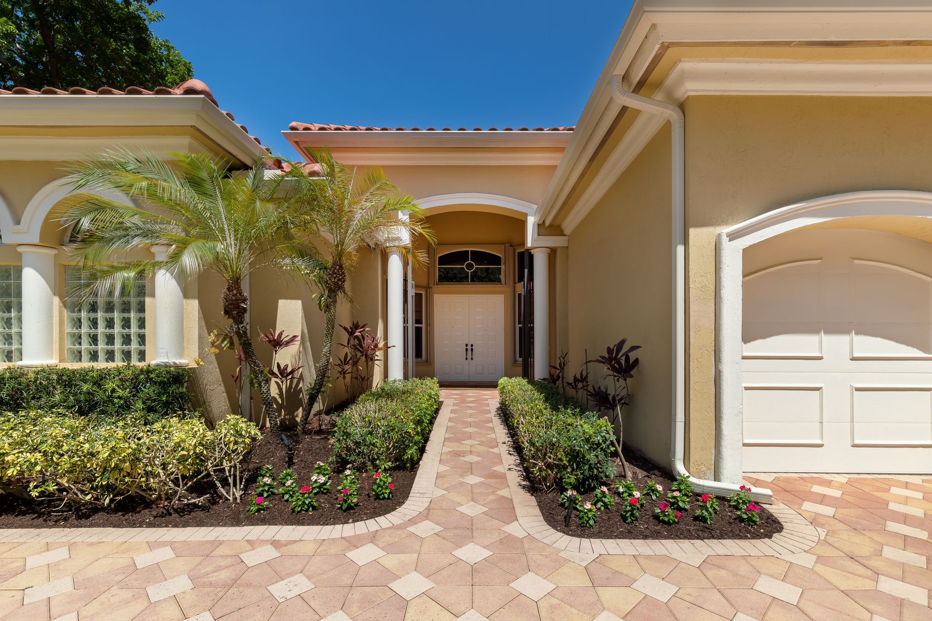 A large house with a brick driveway leading to it