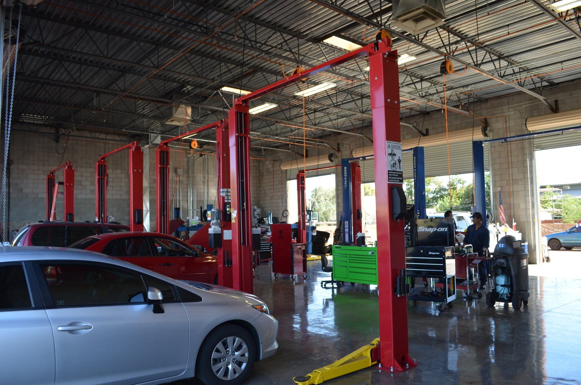 A car is sitting on a lift in a garage.
