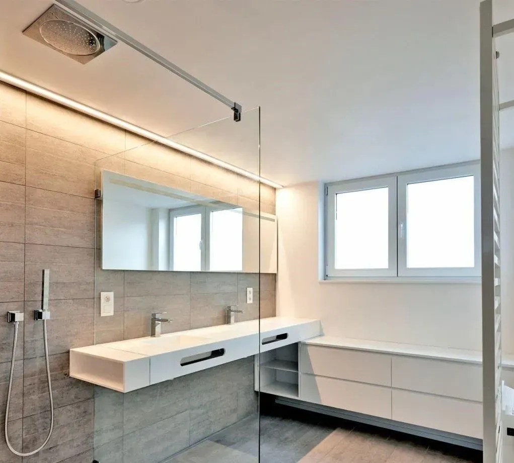 A bathroom with two sinks and a walk in shower