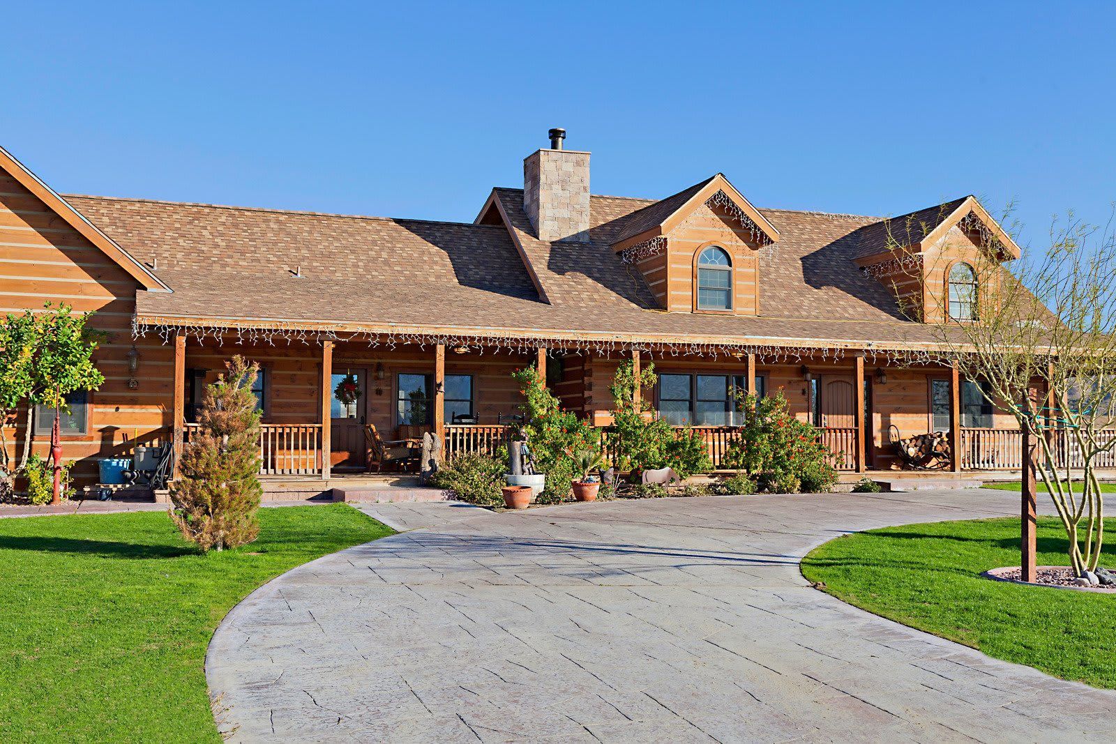 A large log cabin with a driveway leading to it