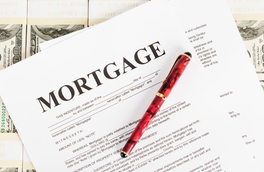 A pen is sitting on top of a piece of paper that says mortgage.