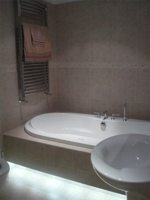 Sunken bath with lights, tiling and sink