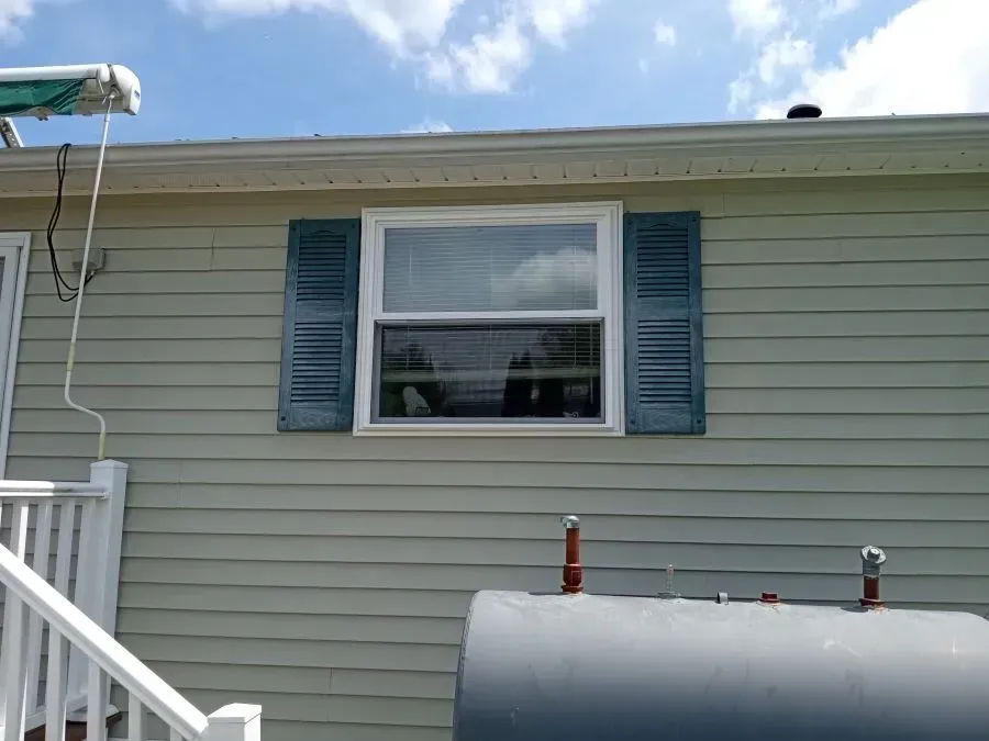 A house with a large window and blue shutters