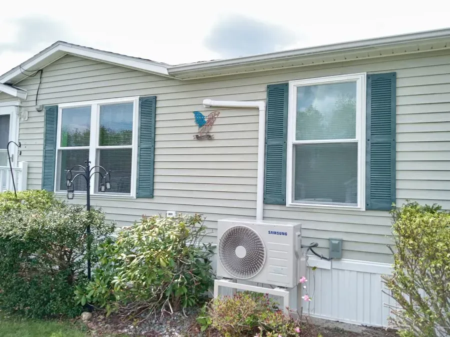 A mobile home with a large air conditioner on the side of it.