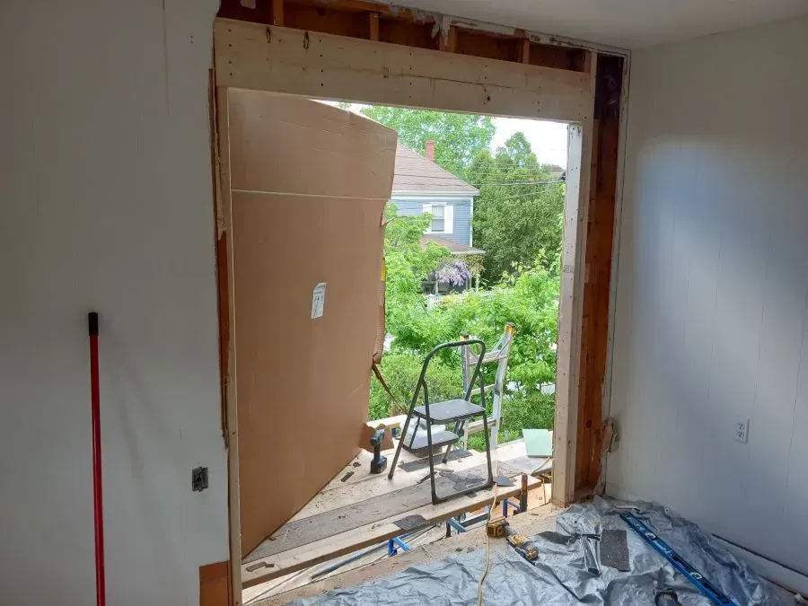 A room with a large window and a chair in it.