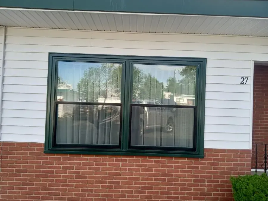A large window on the side of a brick house.