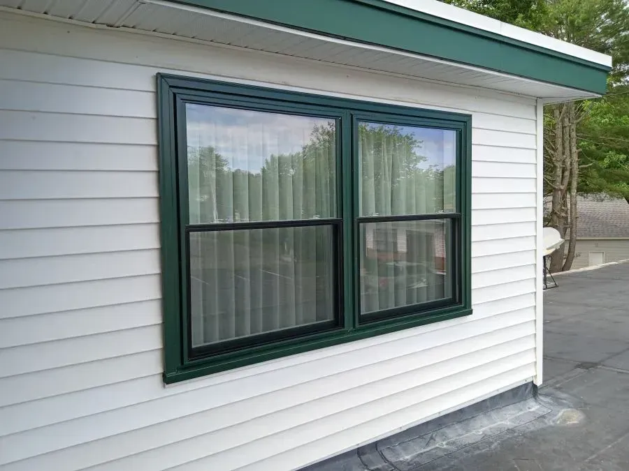 A white house with a green window on the side