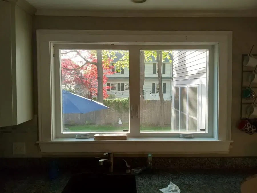 A kitchen with a large window and a sink.