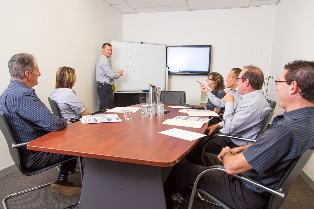 Man is Giving a Presentation to a Group of People in a Conference Room — Forsyths Accounting Services Pty Ltd in Mackay, QLD