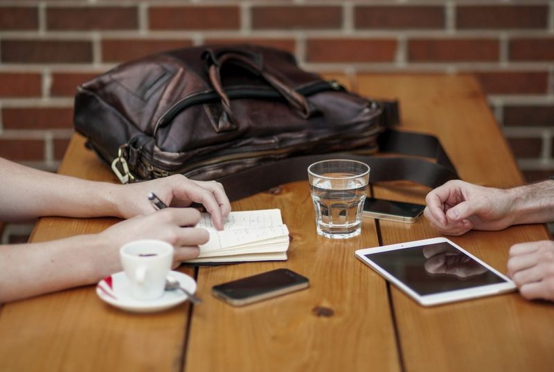 Two People Are Sitting at a Table With a Tablet and a Cup of Coffee — Forsyths Accounting Services Pty Ltd in Mackay, QLD