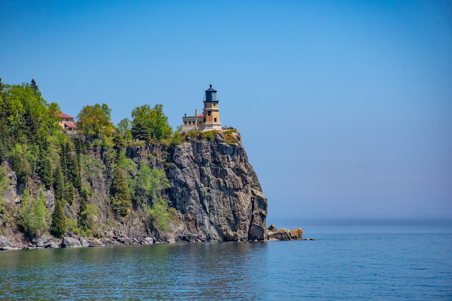 A lighthouse on top of a rocky cliff overlooking the ocean.