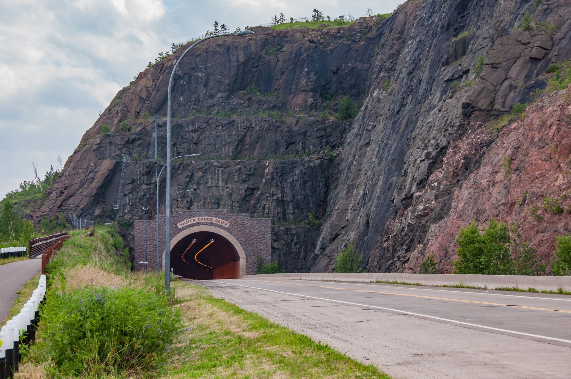 A road with a tunnel going through a mountain.