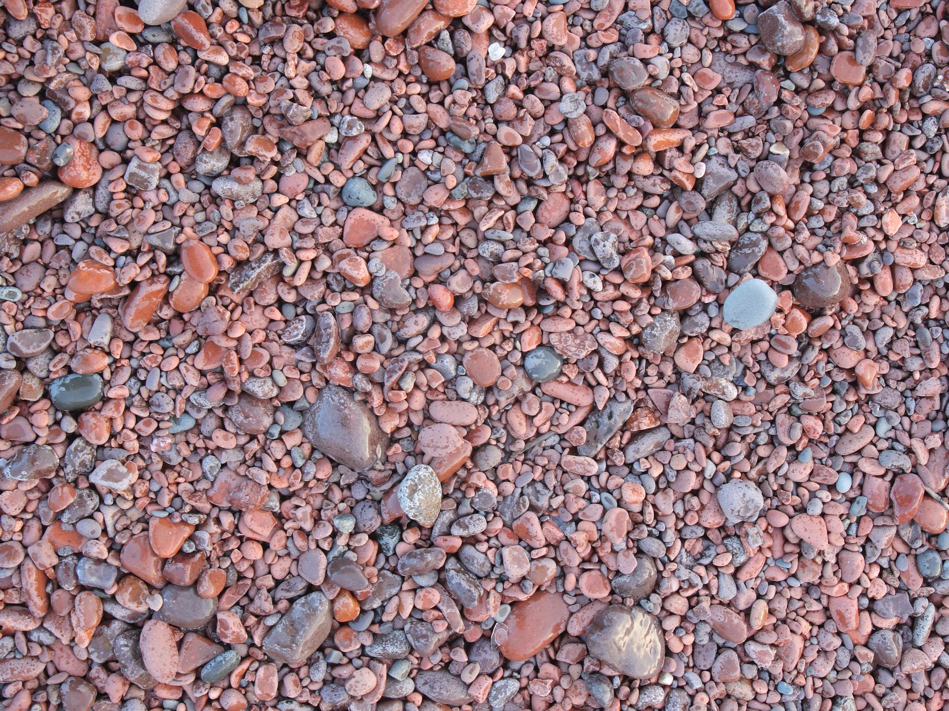A pile of red gravel and rocks on the ground.