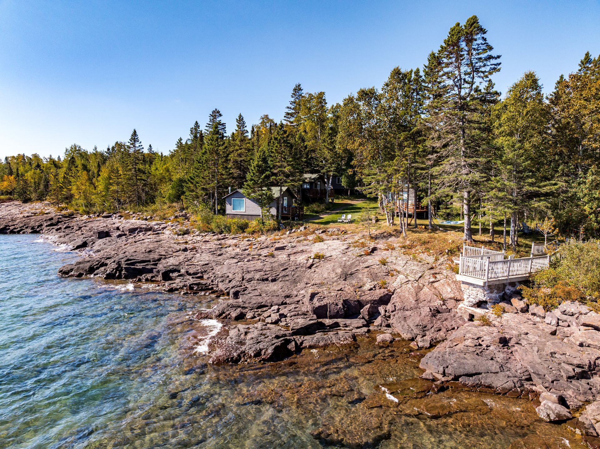 There is a house on the shore of a lake surrounded by trees.