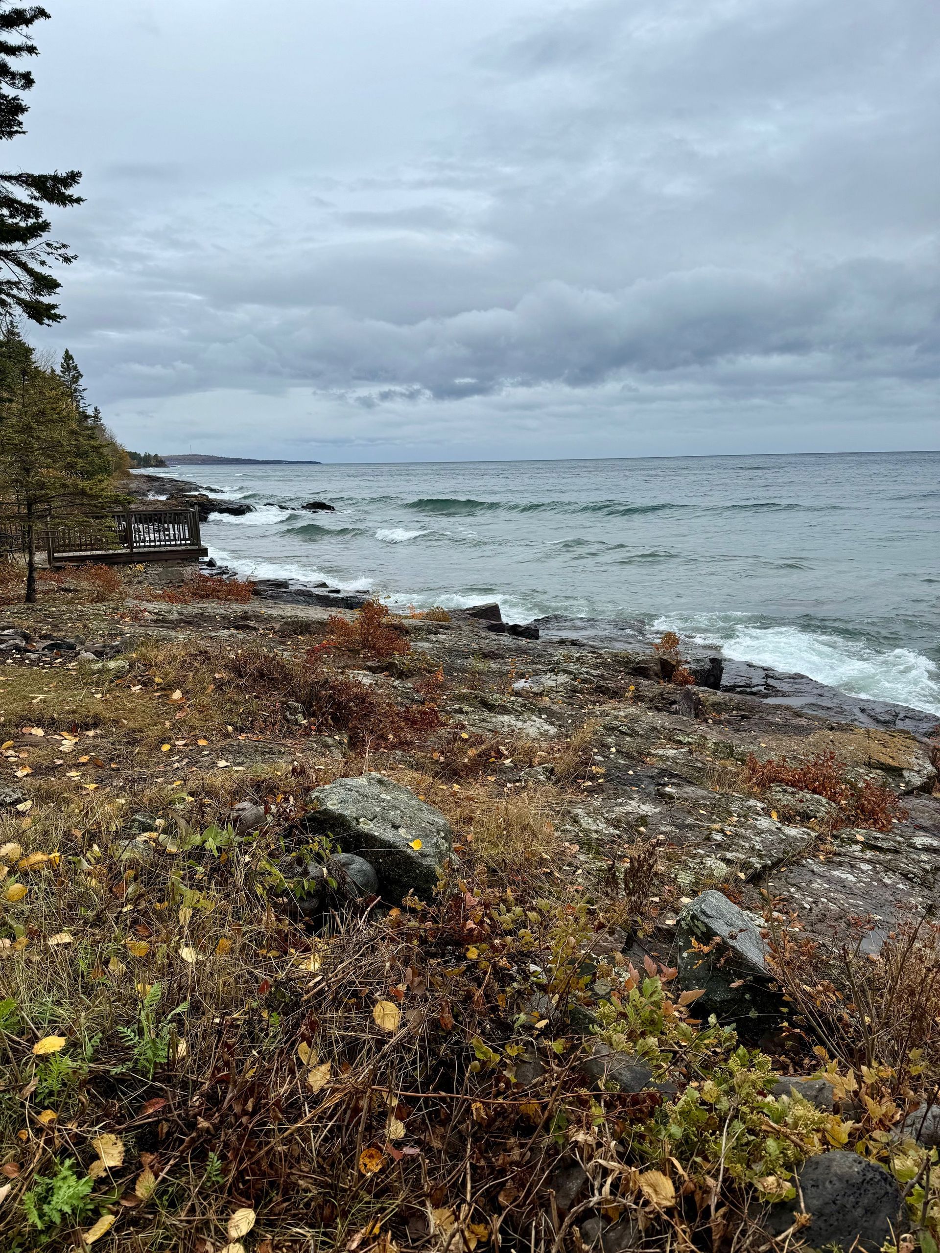 A view of the ocean from a rocky shoreline on a cloudy day.