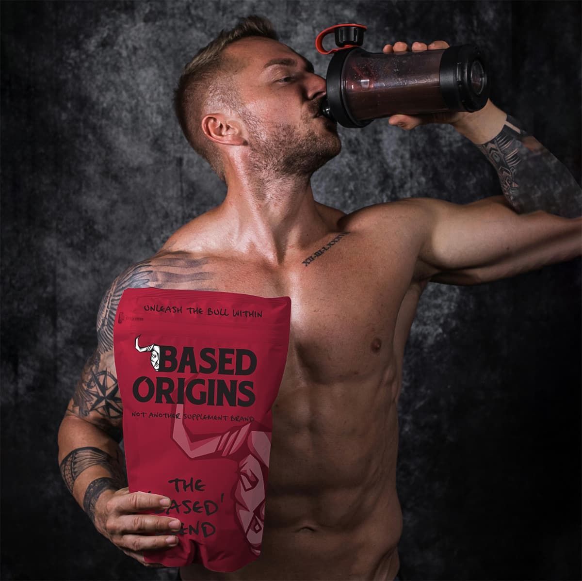 A man stands holding a custom based origins graphic designed packaging thats red with custom bull illustration