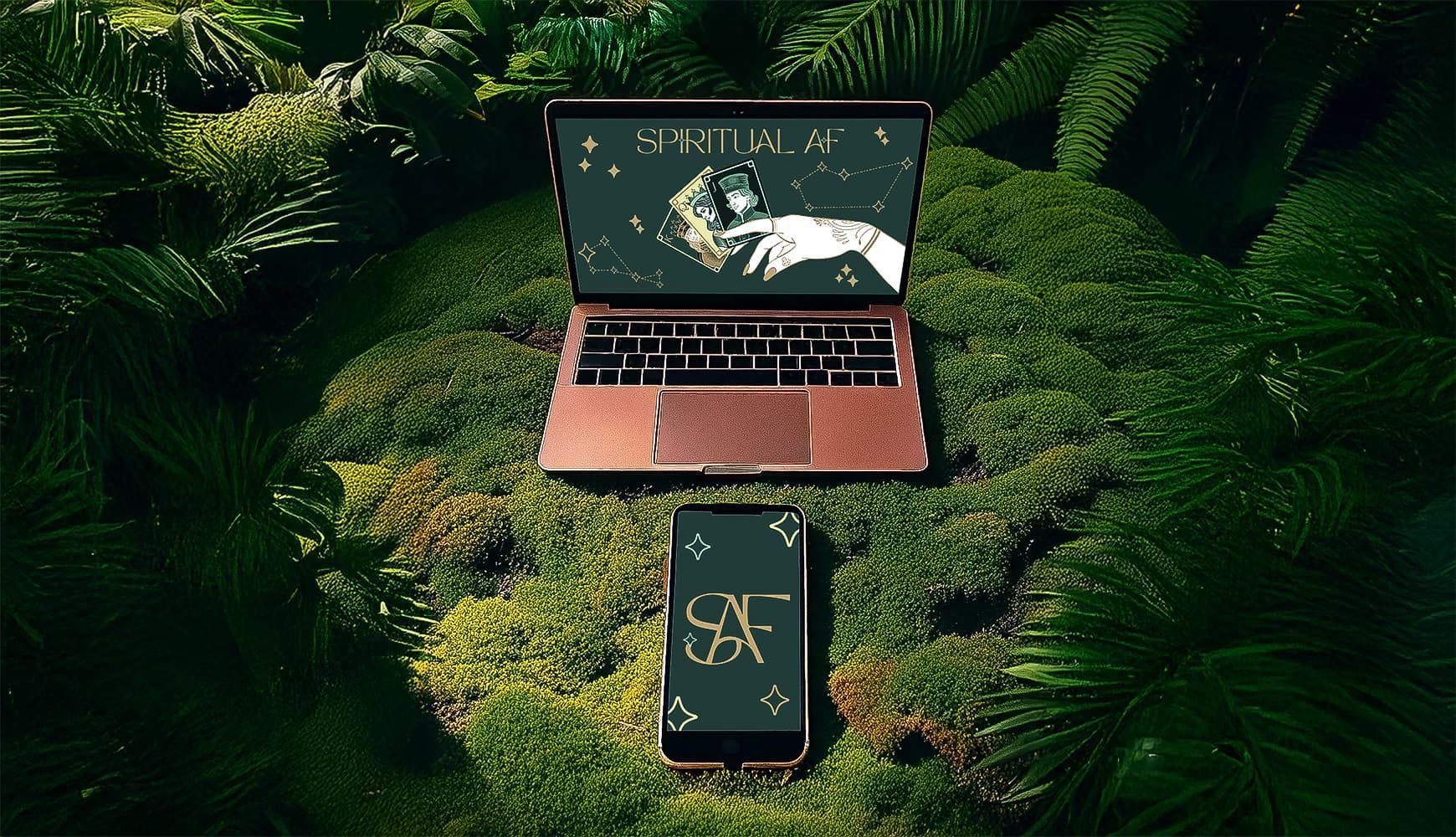 Laptop sitting on a bed of moss displaying a custom website mockup graphic designed by Disarming Designs for Spiritual AF