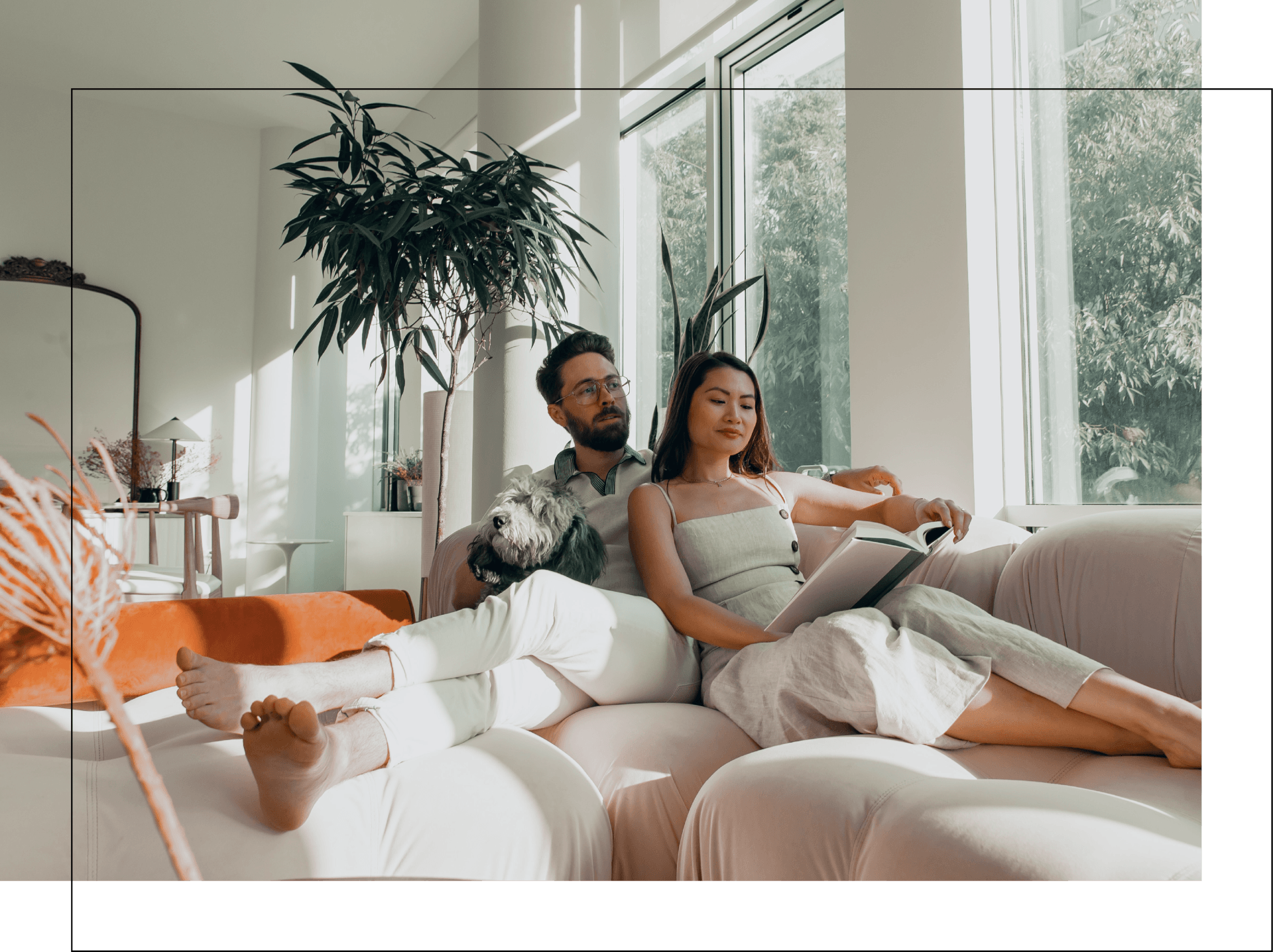 A man and a woman are sitting on a couch reading a book.