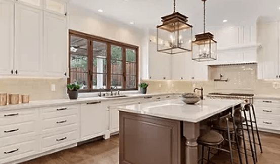 A kitchen with white cabinets and a large island in the middle.