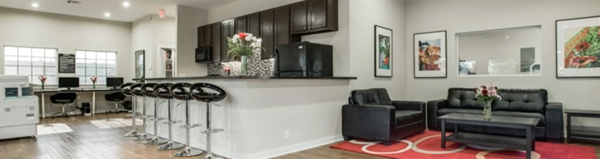 wide angle photo of living room entrance and barstool area of kitchen
