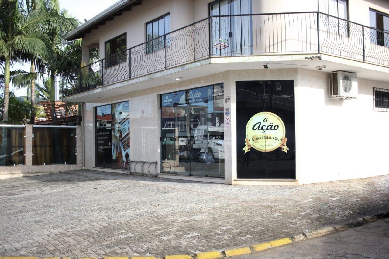 Um prédio com uma sacada e uma placa que diz acao