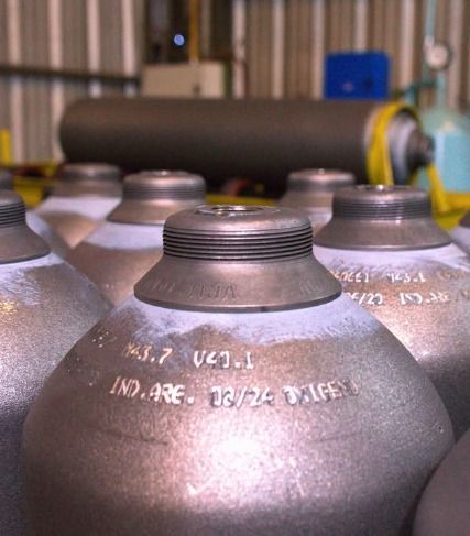 Válvula de gas de latón con manija negra y conexiones roscadas.