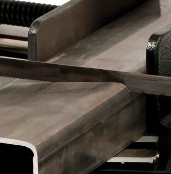 Hoja de sierra de cinta en espiral con respaldo azul, con dientes de sierra a lo largo de un borde y etiquetada 